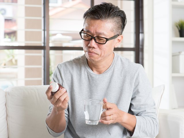 薬を飲む男性